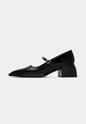 Scarpa Mary Jane in vernice nera con punta affusolata, cinturino regolabile e tacco a blocco, caratterizzata da una finitura lucida e un design minimalista.