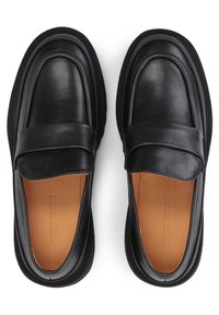 Mocassins en cuir noir avec une texture lisse, bout rond et large bande sur le dessus. L'intérieur présente une doublure en cuir naturel.