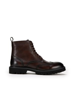 Bruine leren enkelboot met brogue-details, ronde neus, vetersluiting, trekband en robuuste zwarte rubberen zool.