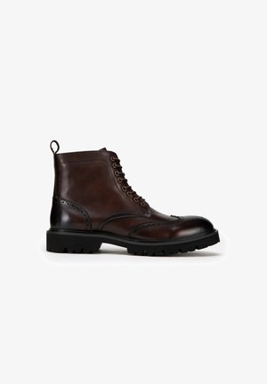 Brązowy skórzany trzewik z detalami w stylu brogue, okrągłym noskiem, sznurowanym przodem, pętlą do zakupu oraz wytrzymałą czarną gumową podeszwą.