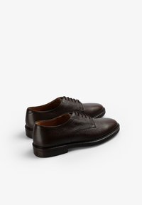 Braune Leder-Dressschuhe mit strukturiertem Finish, runder Zehenpartie und Schnürdesign. Mit glatter Sohle und minimalen Nähdetails.