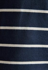 Tumedat sinine kangas, millel on ühtlaselt jaotatud, õhukesed valged horisontaalsed triibud, näidates kudumitekstuuri ja pehmet materjali.