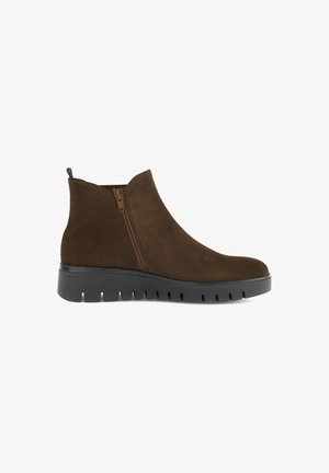 Bottines en velours brun avec une fermeture éclair latérale, bout rond et semelle épaisse en caoutchouc noir avec des détails crantés.