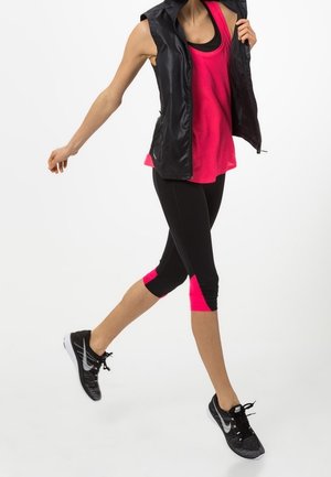 Black sleeveless vest, fuchsia tank top, black capri leggings with pink accents, and black athletic shoes with white detail.