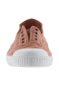 Scarpa slip-on in tela di colore rosa chiaro con suola in gomma bianca, dotata di cinque occhielli metallici e una parte superiore testurizzata per una maggiore aderenza.