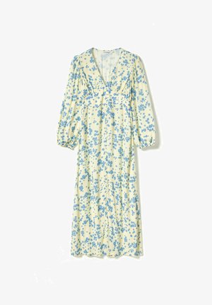 Cvetlična obleka v svetlo rumeni barvi z modrimi cvetličnimi vzorci, z izrezom v obliki črke V, dolgimi napihnjenimi rokavi in nabranimi detajli na prsih. Dolžina do tal.