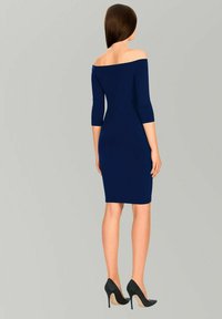 Abito bodycon blu navy off-the-shoulder con maniche a tre quarti, superficie liscia, forma aderente, abbinato a tacchi alti neri.