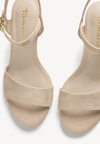 Sandales ouvertes en daim beige avec brides à la cheville et boucle dorée, taille 37, marque Tamaris.