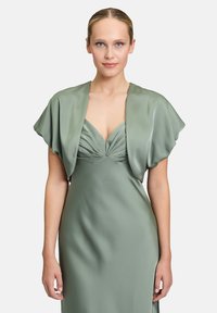 Groene satijnen jurk met geplooide bodice en een schouderstijl korte overlay. Gladde textuur, getailleerd silhouet en een diepe V-hals.