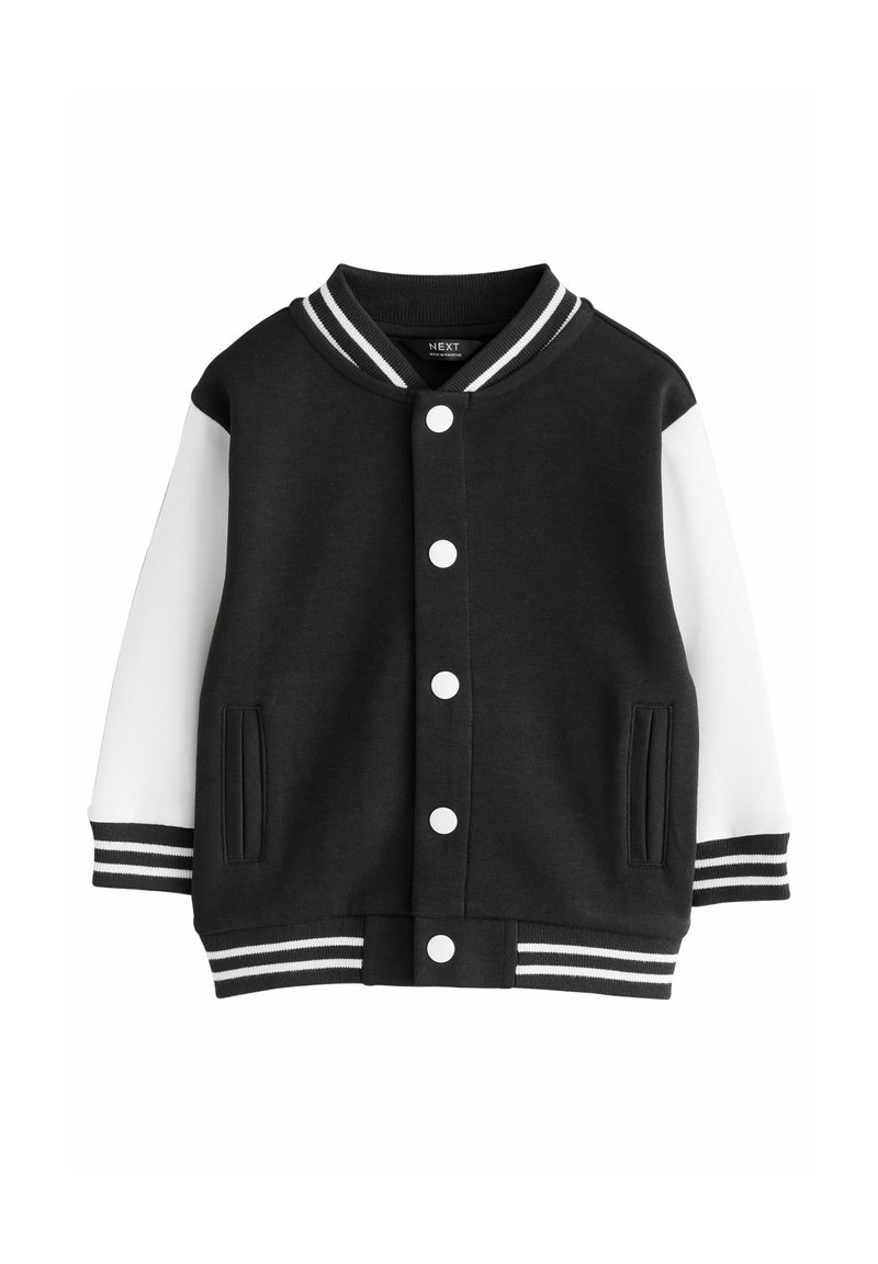 Chaqueta varsity en blanco y negro con cierre de botones en el frente, mangas blancas, puños a rayas, cuello y cintura, y dos bolsillos delanteros.