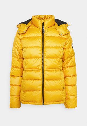 Veste matelassée jaune avec capuche noire amovible, fermeture éclair devant et détails à boutons-pression aux épaules.