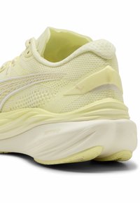 Puma tenisice za trčanje u svijetloj žutej mrežastoj tkanini, s zaobljenim petama, teksturiranim detaljima na gornjem dijelu i suptilnim logom na peti.
