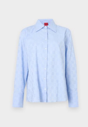 Jasnoniebieska koszula z długim rękawem, kołnierzykiem na guziki, subtelnym tłoczonym wzorem i białymi guzikami na przedniej listwie.