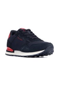 Basket de sport bleu marine avec des accents rouges, fabriquée en tissu respirant et en suede. Dispose d'une semelle intermédiaire blanche et d'une semelle extérieure en caoutchouc noir texturé.