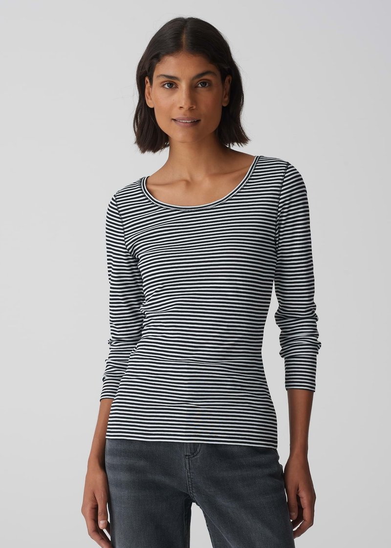 Schwarz-weiße gestreifte Langarmbluse mit rundem Ausschnitt, aus weichem Stoff, enganliegendem Schnitt und kombiniert mit dunklen Denim-Jeans.