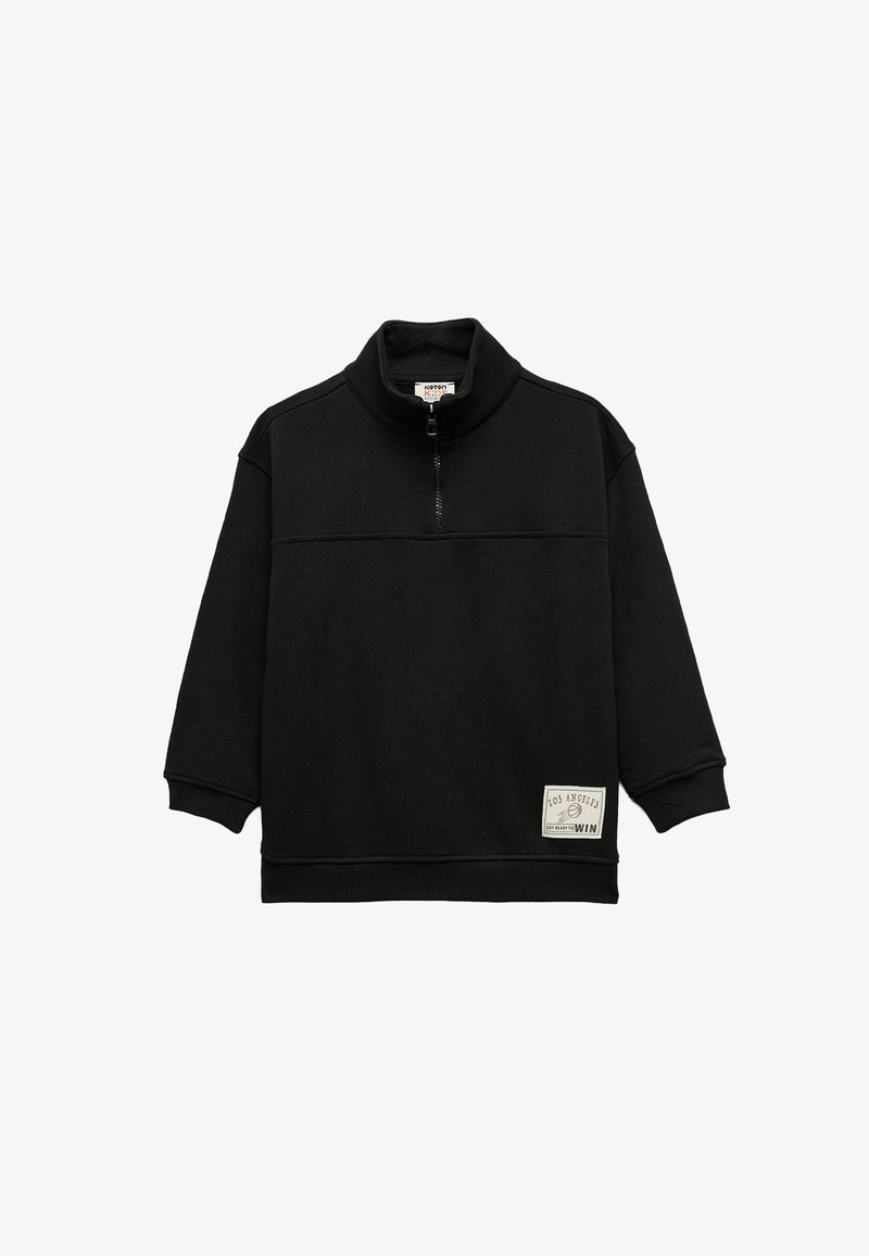 Chaqueta negra de pulóver con cuello alto y media cremallera, que presenta mangas largas, una tela texturizada y un parche de logo rectangular en la parte delantera.