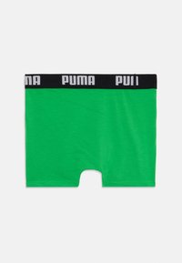 Grüne Baumwoll-Boxershorts mit einem schwarzen Bund, der das weiße "PUMA"-Logo trägt. Rechteckige Form mit einer glatten Textur und elastischem Sitz.