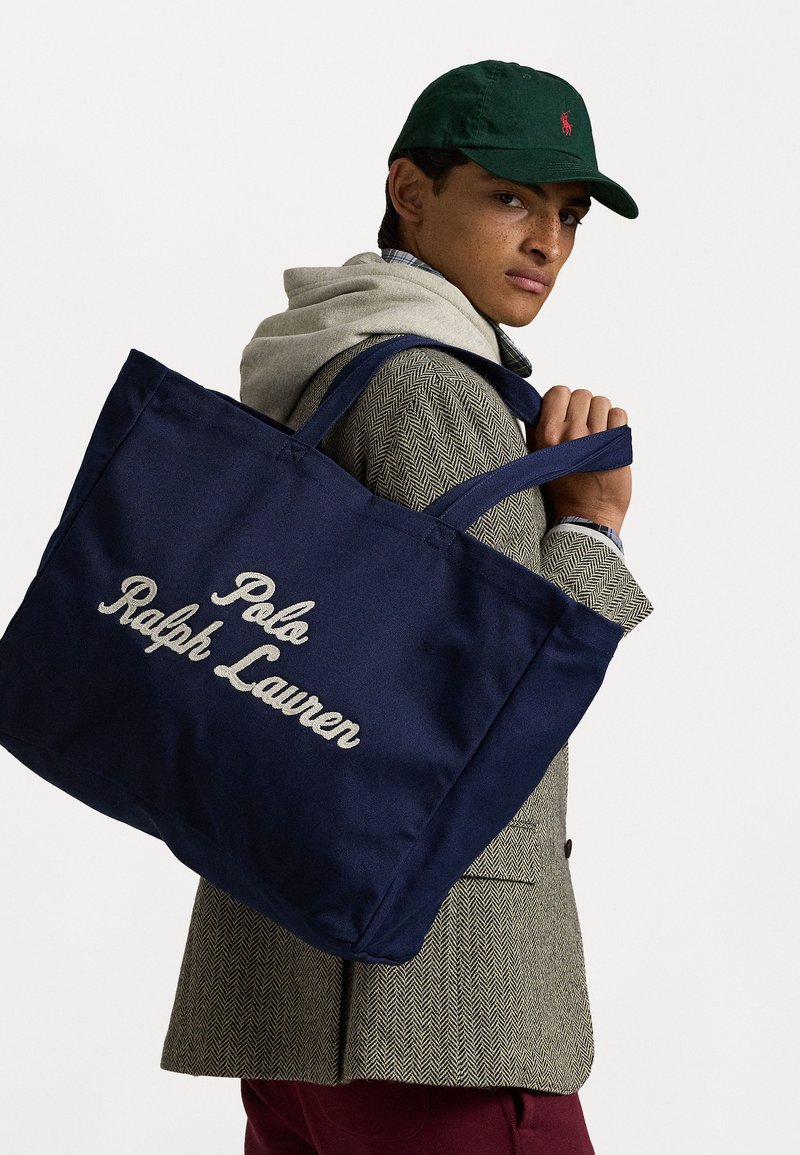 Jūrinis nešiojamas krepšys su išsiuvinėtu "Polo Ralph Lauren" logotipu; patvari medžiaga, dvi petnešos ir didelis dydis daiktams nešti.