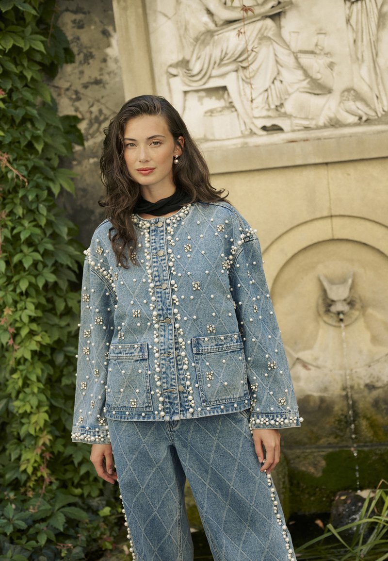 Zila denima jaka ar pērļu rotājumiem, dimanta raksts, apaļa apkakle, pogu aizdare, sakombinēta ar atbilstošām platām biksēm.