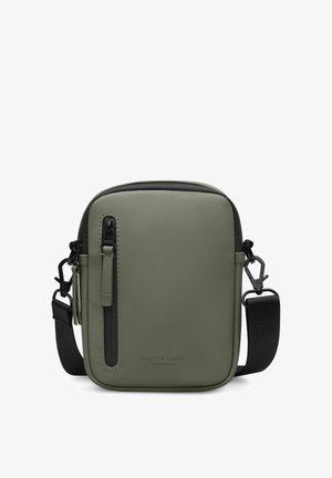 Compacte crossbodytas in olijfgroen met zwarte verstelbare riem, verticale voorzak met ritssluiting en een gladde matte afwerking.