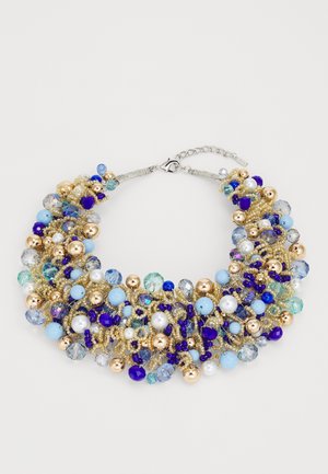 Collana in perline con perline blu, dorate e trasparenti, di diverse dimensioni e forme, assicurata con una catena e una chiusura a gancio.