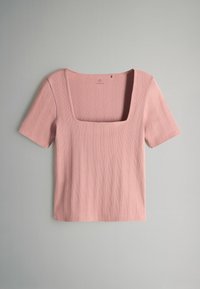 Krátky rukáv, top s štvorcovým výstrihom v svetloružovej rebrovanej látke. Má vertikálne pruhy a mäkkú textúru. Neformálny dizajn vhodný na vrstvenie.