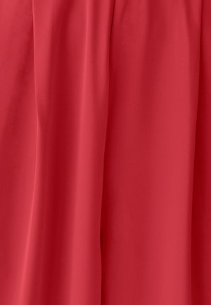 Raudona medžiaga su lygiu paviršiumi ir švelniais klostėmis, formuojančiomis vertikalius drapavimus.