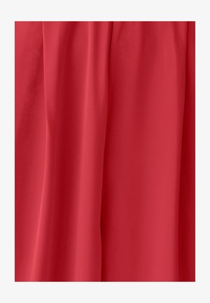 Raudona medžiaga su lygiu paviršiumi ir švelniais klostėmis, formuojančiomis vertikalius drapavimus.