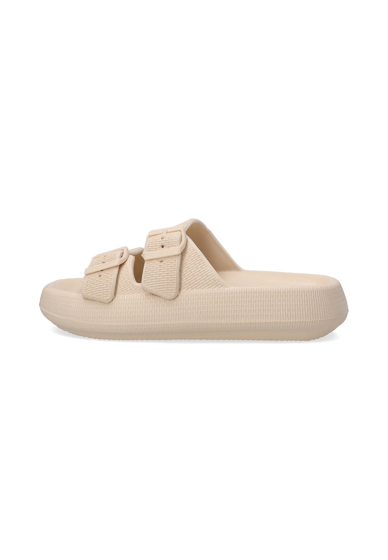 Beige slip-on sandals with two adjustable buckles, textured material, and a thick, ridged sole for enhanced grip and comfort.