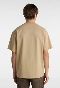 Beige cotton t-shirt with short sleeves, crew neckline, and relaxed fit. Smooth texture, no visible patterns or embellishments.