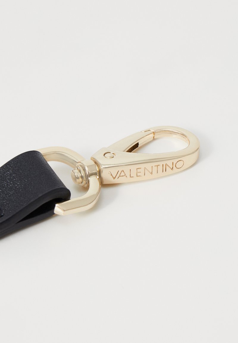 Boucle en métal doré avec une sangle texturée noire, arborant le nom de marque gravé "VALENTINO" sur le matériel.