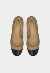 Ruskind balletsko i lysebrun med sort tåhætte. Glat tekstur med rund form og minimalistisk design. Guldlogo detalje indvendigt.