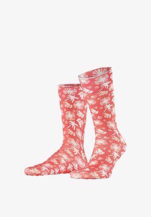 Chaussettes rose corail avec des motifs abstraits blancs de fleurs et de feuilles, présentées debout sur un fond blanc.