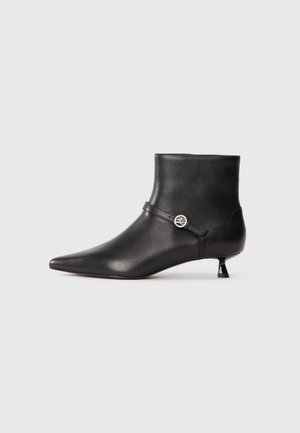Stivale in pelle nera alla caviglia con punta affusolata, asta aderente, tacco kitten di piccole dimensioni e dettaglio decorativo fidato vicino alla caviglia. Texture liscia.