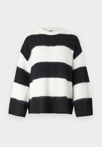 Pull en maille floue noir et blanc avec de larges rayures horizontales et un col rond, présenté sur un fond clair uni.