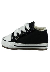 Chaussure en toile noire avec capuchon en caoutchouc blanc, lacets blancs et coutures. Dispose d'une semelle texturée et d'un design basse.
