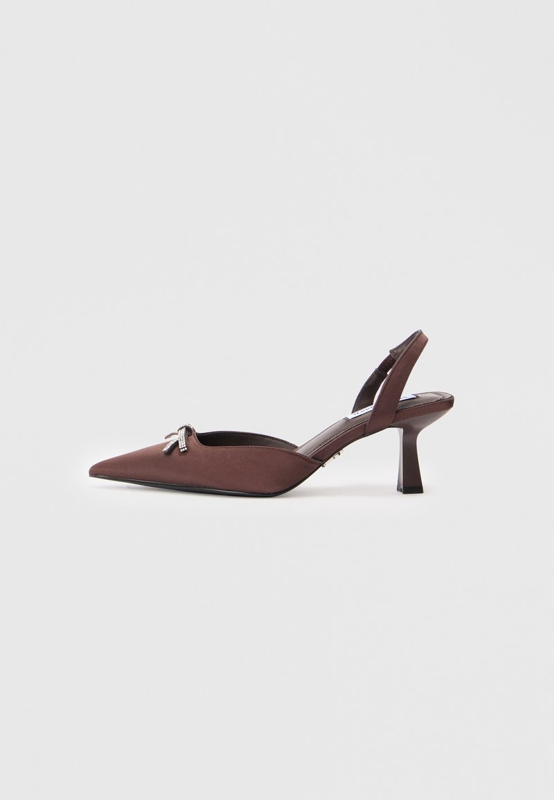 Tacones slingback de ante marrón con puntera puntiaguda, que presentan un tacón bajo y un detalle decorativo de lazo metálico. Forro interior suave.