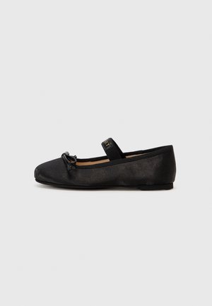 Sort ballerina flad sko med lille sløjfe på tåen og en elastisk rem over toppen, vist fra siden på en hvid baggrund.