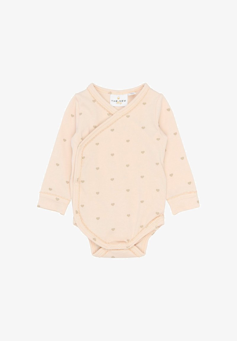 Body de bébé à manches longues de couleur crème avec des motifs de cœurs beiges et des boutons pression sur le côté et le bas.
