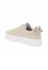 Zapatilla de piel sintética beige con una suela de plataforma blanca, cordones con ojales y un lazo decorativo en el talón. Textura suave, diseño minimalista.