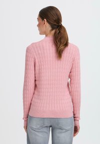 Maglione a coste di un rosa chiaro, con un motivo testurizzato, maniche lunghe e un design aderente. Rifinito con un collo rotondo e polsini a coste.