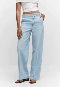 Jeans de pernera ancha de color azul claro, confeccionados en denim con una cintura alta. Cuentan con un cierre frontal de botón y cremallera, bolsillos laterales y un ajuste relajado.