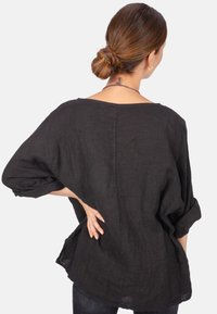 Schwarze Leinenbluse mit lockerer Passform, weiteren Ärmeln und einem Schiffsausschnitt. Verfügt über einen leichten Glanz und eine weiche Textur. Rüschenärmel unterstreichen das legere Design.