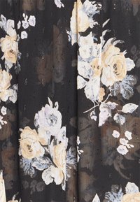Black fabric with large, light floral patterns in cream and soft blue. Features textured surface with small, metallic accents throughout.