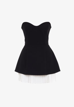 Schwarzes trägerloses Kleid mit eng anliegendem Oberteil und ausgestelltem Rock. Ein weißes, plissiertes Unterkleid sorgt für einen Kontrast. Das Material wirkt glatt und strukturiert.