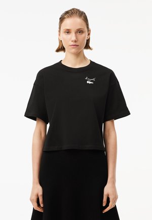 Sort kortærmet t-shirt i bomuld med rund halsudskæring, korte ærmer og hvidt broderet logo på brystet.
