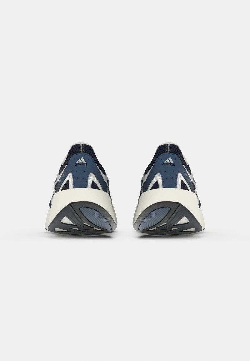 Baskets de sport bleu marine avec accents blancs, tige en maille et synthétique, bout rond, col rembourré et semelle extérieure en caoutchouc noir texturé.