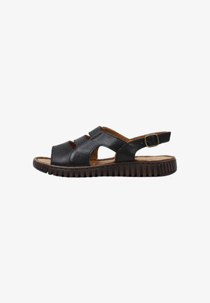 Sandalia masculina de cuero negro con puntera abierta, correa ajustable con hebilla y suela marrón resistente diseñada para la comodidad y el uso informal.