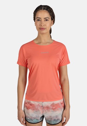 Coral athletic t-shirt with short sleeves and round neckline, paired with patterned shorts in pastel colors. Material appears lightweight.