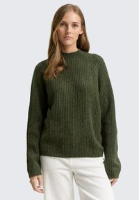 Olivgrüner, gerippter Strickpullover mit hohem Kragen und langen Ärmeln. Besitzt eine lockere Passform und abgesenkte Schulternähte.